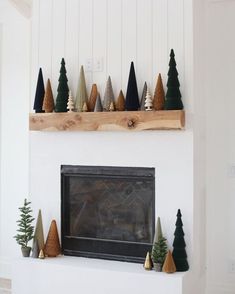 a fireplace with christmas trees on the mantel