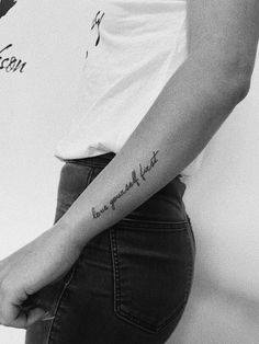 a person with a small tattoo on their left arm and the word love is written in cursive writing