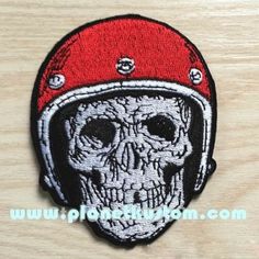 a patch with a skull wearing a red helmet on it's head and eyes