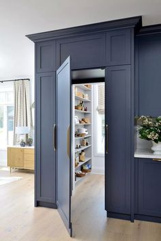 an open door leading into a kitchen with blue cabinets