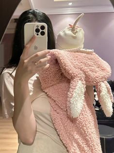 a woman taking a selfie with her cell phone while wearing a pink bunny costume