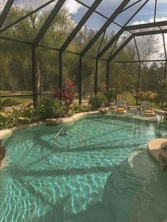 an indoor swimming pool surrounded by plants and trees