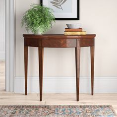 a table with a potted plant on top of it next to a framed photograph