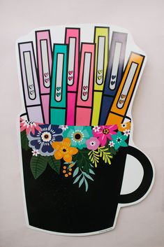 a coffee cup filled with colorful office supplies