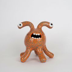 an orange and blue ceramic monster with its mouth open