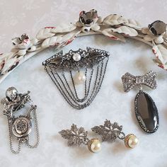 Silver Brooch With Chain For Formal Occasions, Elegant Silver Metal Brooches, Elegant Brooches For Vintage Events, Classic Silver Party Pins, Elegant Vintage Collection Jewelry, Elegant Chain Brooch For Gift, Elegant Metal Brooch Jewelry, Elegant Vintage Brooch Pins, Elegant Silver Pins For Gifts