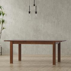 a wooden table sitting on top of a tiled floor next to a potted plant