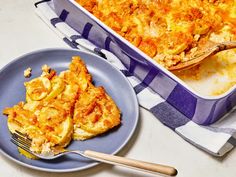 a blue plate topped with food next to a casserole dish and a fork