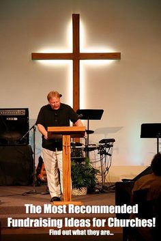 a man standing at a podium in front of a cross