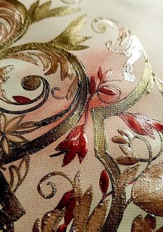 an embroidered fabric with gold and red flowers on it