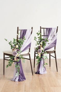 two chairs with purple sashes and flowers on them, sitting side by side in front of each other