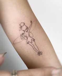 a woman's arm with a small tattoo on the back of her left arm