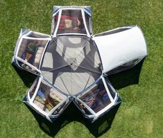 an upside down view of a tent in the grass with pictures on it's sides