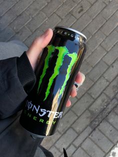 a person holding a can of monster energy drink