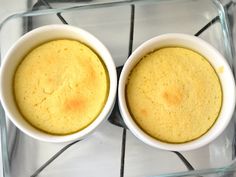 two white bowls filled with food sitting on top of a glass stove burner oven