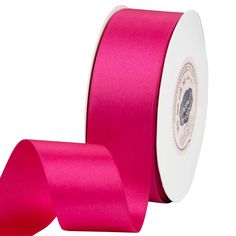 a roll of bright pink satin ribbon on a white background