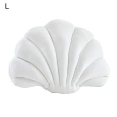 a white shell shaped pillow sitting on top of a table