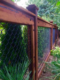 a wooden fence surrounded by plants and trees