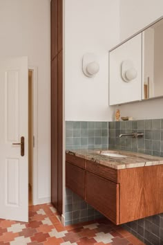 a bathroom with tiled floors and wooden cabinets