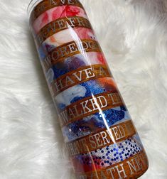 a red, white and blue water bottle sitting on top of a fluffy white blanket