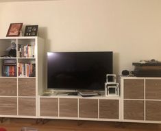 a living room with a large television and bookcases