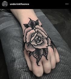 a black and white rose tattoo on the left hand, with an arrow in the middle