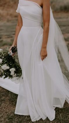 a woman in a white wedding dress holding a bouquet