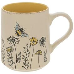 a coffee mug with flowers and a bee on it