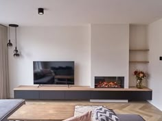 a living room with a couch, fireplace and television on the wall in front of it