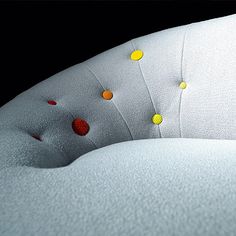 an upholstered white couch with yellow and red dots on it