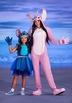 a woman and girl dressed up in costumes on the beach