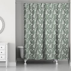 a bathroom with a green shower curtain next to a white dresser and mirror on the wall