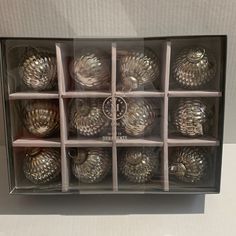 a box filled with lots of shiny silver objects in it's display case on top of a table