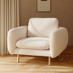 a white chair sitting on top of a hard wood floor next to a window with curtains