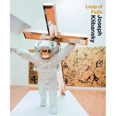 an astronaut is holding up a wooden cross