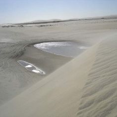 the sand dunes are covered with water and white sands, as well as small puddles