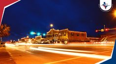 an image of a city street at night with blurry lights on the buildings and trees