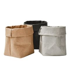 three different colored paper bags sitting next to each other