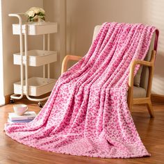 a pink blanket sitting on top of a wooden chair