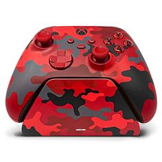 a red and black controller with buttons on it's side, in front of a white background