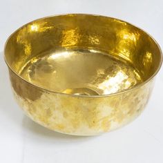 a golden bowl sitting on top of a white table