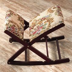 a wooden rocking chair with floral upholstered seat padding on the back and sides