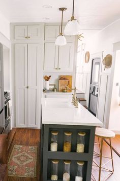 a kitchen with white cabinets and wooden floors