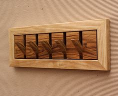 a wooden frame with several pieces of wood in it hanging on the side of a wall