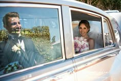 the bride and groom are in their wedding car