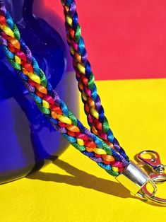 This LGBTQ Pride wristlet keychain is woven in a Kumihimo style flat braid with 8 strands of 2mm thick nylon satin thread.   The wristlet band is hand-braided in the LGBTQ Pride flag colors: fuchsia, red, orange, yellow, green, turquoise, blue and purple.  The length of the woven band is 6 inches, and the total length(including key ring and large lobster clasp hook) is 8-1/4 inches. This is a perfect way to show your Pride on any handbag, backpack or carry bag.  It's a great gift for Pride Month Lgbtq Pride Flag, Pride Flag Colors, Vert Turquoise, Lanyard Keychain, Wristlet Keychain, Lgbtq Pride, Flag Colors, Pride Flag, Green Turquoise