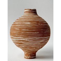 a brown and white vase sitting on top of a table