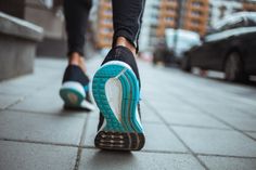 a person walking down the street with their feet on the ground and wearing running shoes