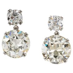 A pair of diamond drop earrings, the two round shape old-cut diamonds, weighing 4.26 carats of M colour and P1 clarity and 4.85 carats of L colour and SI1 clarity, each suspended from a smaller old-cut diamond, weighing 0.91 and 0.86 carats, all four claws set in platinum, with screw fitting, gross weight 6.5 grams. A stunning pair of diamond drop earrings. These earrings each feature an impressive and dazzling diamond, both weighing over four carats, suspended from a smaller glittering diamond. Large Diamond Stud Earrings, Antique Diamond Earrings, Diamond Huggie Earrings, Diamond Cluster Earrings, Dragonfly Earrings, Pearl And Diamond Earrings, Knot Earrings, Jewellery Shop, Bespoke Jewellery