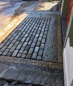 a brick sidewalk next to a garage door